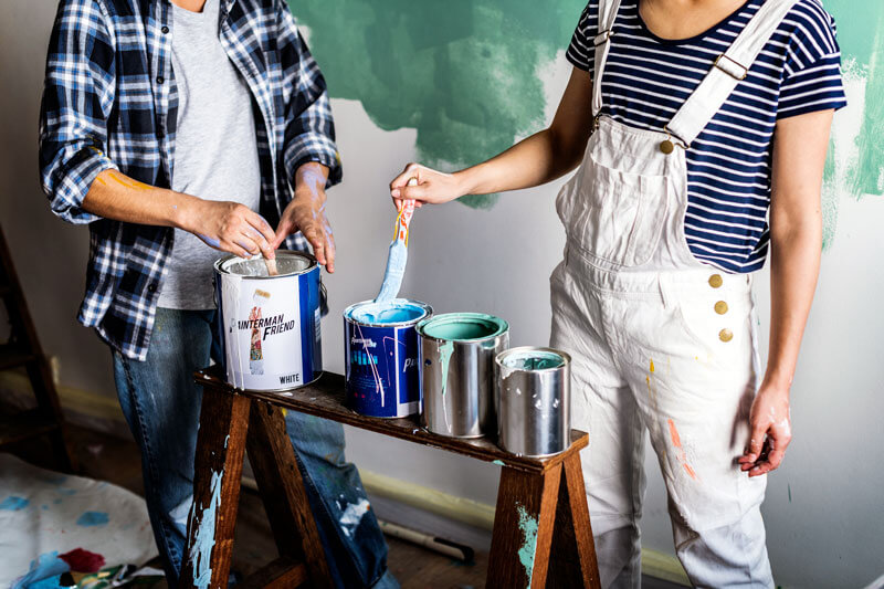 Couple painting interior of house.