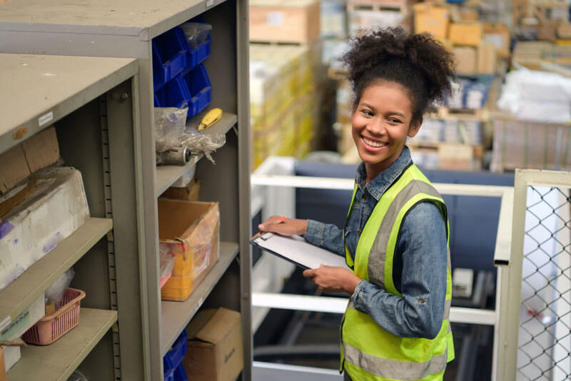 employee of local hardware store smiling while checking inventory